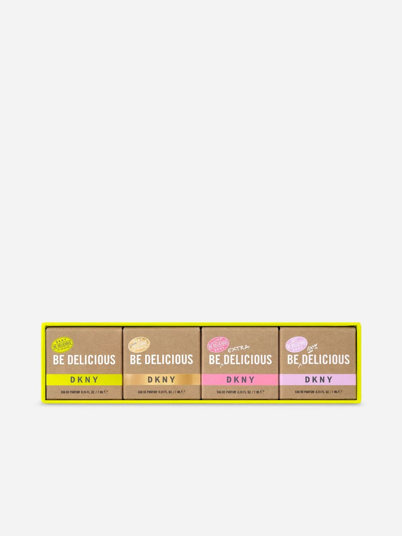 Load image into Gallery viewer, Four boxes from the DKNY Be Delicious Eau de Parfum Mini Set, ideal as a charming perfume gift, are arranged in a row with various colored labels on a pristine white background.
