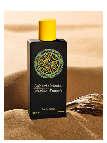 A black and yellow AL Musbah Sahari Oriental 90ml Eau De Parfum bottle labeled "Sahari Oriental Arabian Souvenir" on a sandy background.