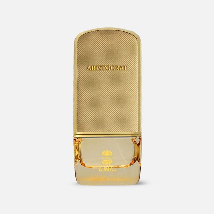 A golden perfume bottle labeled "Ajmal Aristocrat Coral 75ml Eau De Parfum" with a textured cap and a transparent section at the bottom displaying the brand "Rio Perfumes," houses the exquisite Eau De Parfum, Ajmal Aristocrat Coral, a captivating fragrance for men & women.