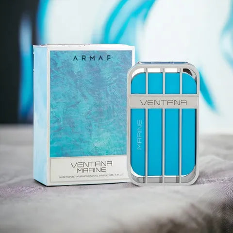 The Armaf Ventana Marine 100ml Eau De Perfum, a woody aquatic fragrance for men, is showcased upright in its striking blue and silver bottle alongside the matching blue and white box on a gray surface.