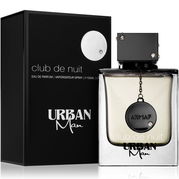 The Armaf Club de Nuit Urban Man 105ml Eau de Parfum, featuring a woody spicy scent, comes with a black cap and emblem. It sits next to a sleek black box showcasing the matching branding. Buy 1 Get 1 Free offer available.