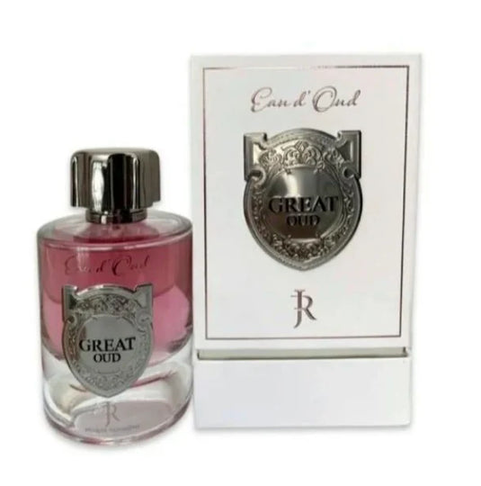 A bottle of "Jacques Richmond Great Oud" Eau De Parfum next to its packaging, featuring a pink liquid and a silver label with an ornate design.