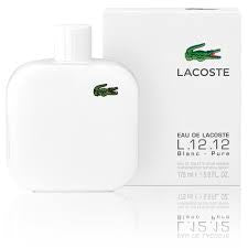 A white rectangular perfume bottle featuring a green crocodile logo, displayed alongside its matching box labeled "Lacoste L.12.12 Blanc 100ml EDT," offers a Woody Aromatic fragrance for men by Lacoste.