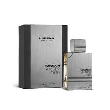 A bottle of Al Haramain Amber Oud Carbon Edition 60ml Eau De Parfum is displayed beside its sleek silver and black packaging box, presenting a sophisticated fragrance for both men and women.