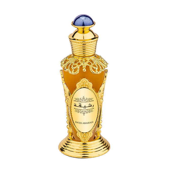 The Swiss Arabian Rasheeqa 20ml Concentrated Perfume Oil boasts a decorative gold bottle adorned with intricate details, featuring a blue-topped cap and Arabic script on the front. This fragrance captivates the senses with its enchanting floral aroma.