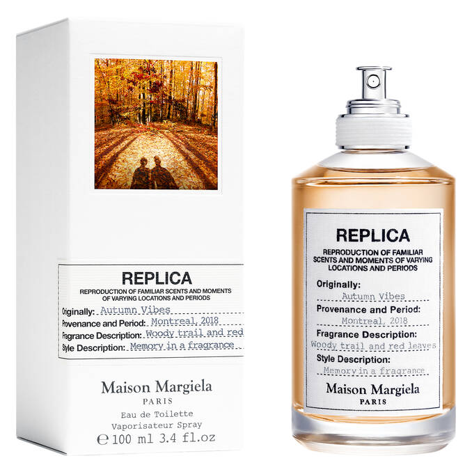 The Maison Margiela Replica Autumn Vibes 100ml Eau De Toilette comes in a stylish bottle and box. The label highlights the scent as "Autumn Vibes," characterized by a woody fragrance with rich notes of cedarwood and vibrant red leaves.