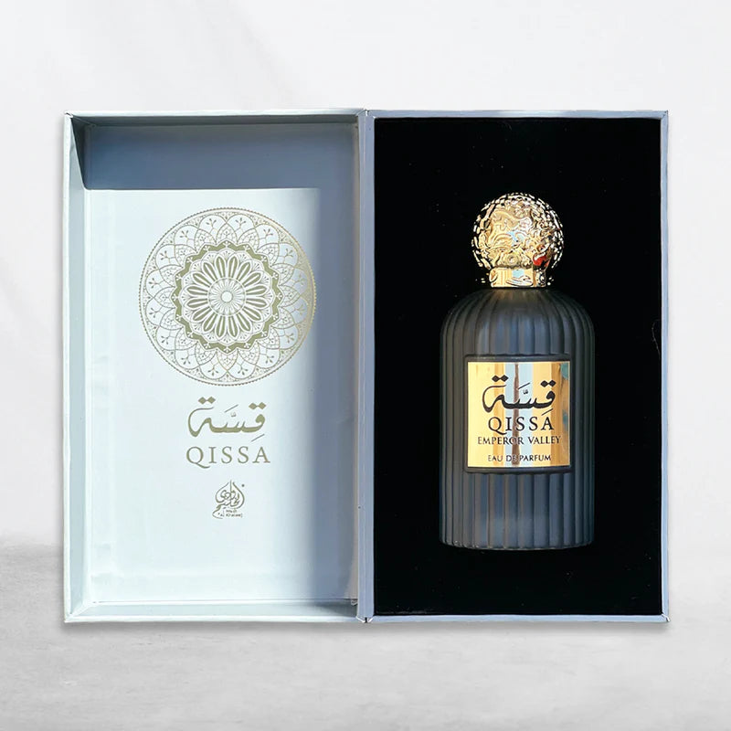 A box with a gold-accented perfume bottle labeled "Qissah Emperor Valley 100ml Eau De Parfum" displayed inside, offering a luxurious fragrance experience from Wadi Al Khaleej.