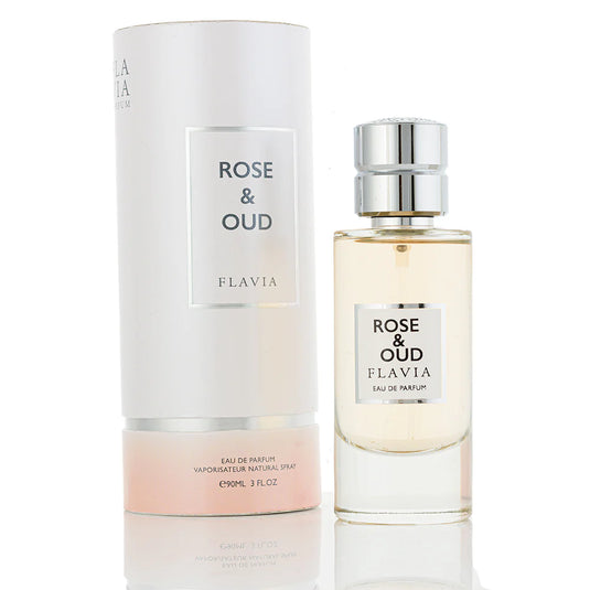 A cylindrical perfume box labeled "Flavia Rose & Oud 100ml Eau De Parfum" sits next to a matching glass perfume bottle with a silver cap, both elegantly showcasing the fragrance brand name "Rio Perfumes".