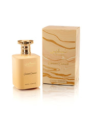 A beige perfume bottle with a gold cap labeled "Paris Corner Taskeen Caramel Cascade" stands next to a matching box with a marbled design and the same text. Paris Corner captures the essence of this Floral Fruity Gourmand fragrance, making it an elegant addition to any collection.