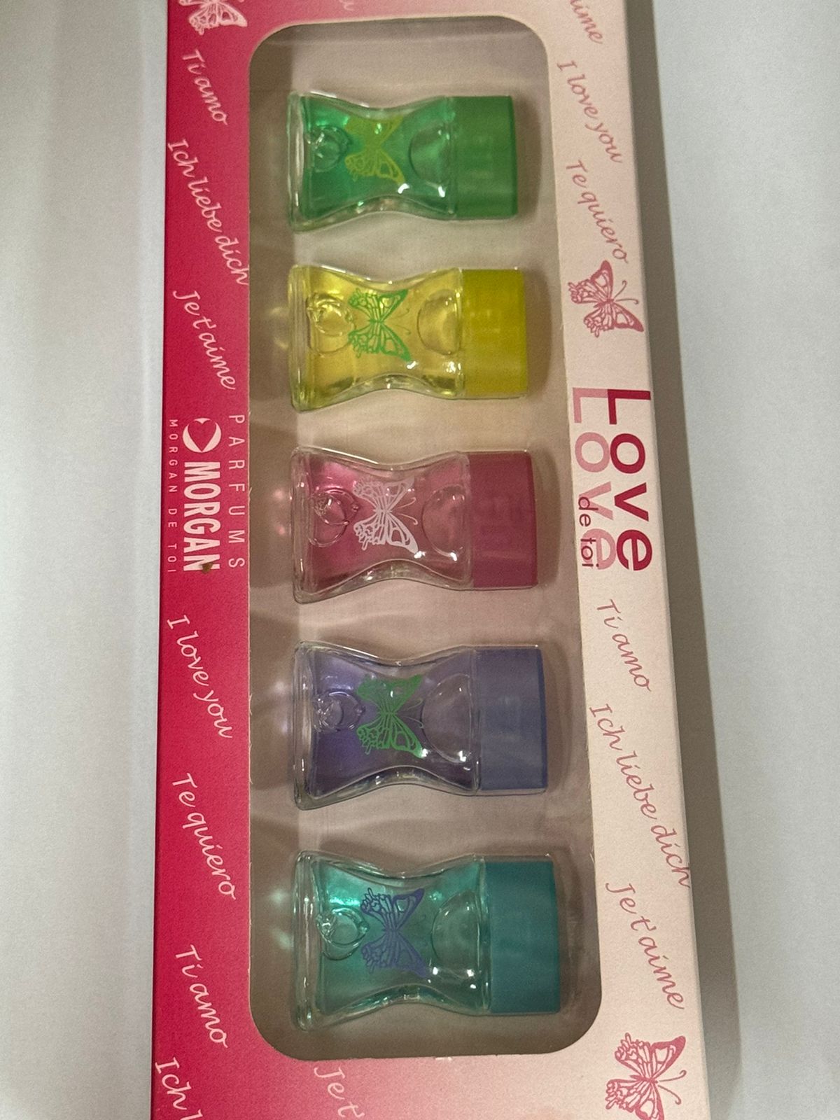 Introducing the Parfums Morgan De Toi Love 5 piece miniature set, a vibrant collection of perfume bottles featuring butterfly designs and labeled "Love" and "Je t'aime." This charming fragrance collection by Parfums Morgan is ideal for any occasion.