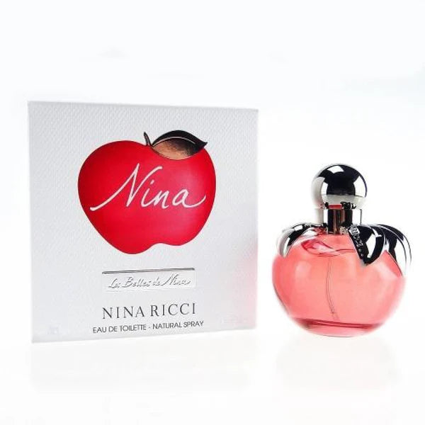 The Nina Ricci Les Belles De Nina 80ml Eau De Toilette bottle and packaging radiate charm. The pink, apple-shaped bottle with a silver cap harmonizes perfectly with the red apple design on the box, encapsulating the essence of an enchanting and alluring fragrance for women.