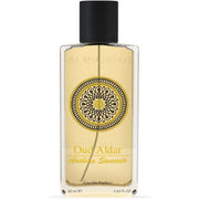 A transparent bottle of Rio Perfumes' "AL Musbah Oud Aldar Arabian Souvenir 90ml Eau De Parfum" with a decorative circular label, containing yellow liquid, against a white background.