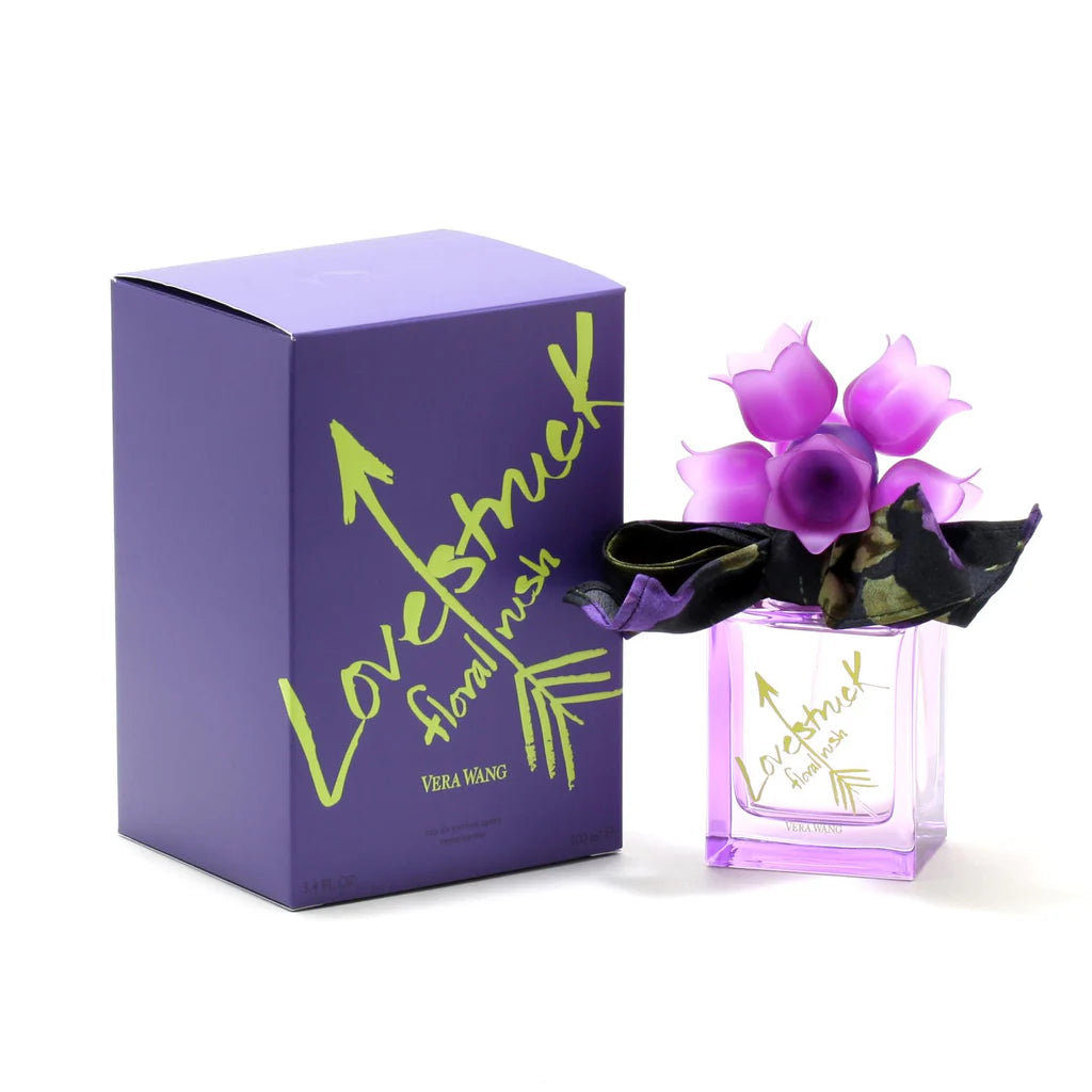 A 100ml bottle of "Vera Wang Lovestruck Floral Rush" Eau De Parfum, adorned with a purple bow and floral cap, is elegantly positioned next to its coordinating purple box featuring green text. This fragrance for women embodies the essence of romance and allure.