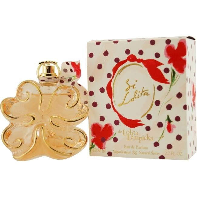 The Si Lolita Lempika 80ml EDP by Lolita Lempicka, with its shamrock flacon, sits beside a decorative box in red and white, capturing the charm of an oriental-floral fragrance.