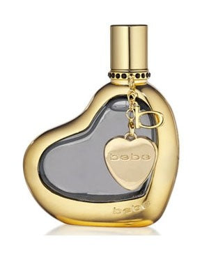 A heart-shaped perfume bottle with a gold cap and a gold heart charm attached. The label reads "Bebe Gold 50ml EDP" by vendor-unknown, capturing the essence of an oriental woody fragrance, perfect for enhancing the autumn atmosphere.