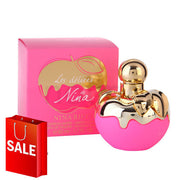 A pink bottle of Nina Ricci Les Delices de Nina 75ml Eau De Toilette fragrance with a shopping bag next to it.