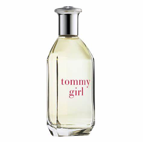 The bottle is made of clear glass with a silver cap and contains a pale yellow liquid. The label displays "Tommy Girl" in red text, indicating it is Tommy Hilfiger's Tommy Girl 100ml Eau De Toilette, a refreshing floral fruity fragrance designed as the perfect scent for women.